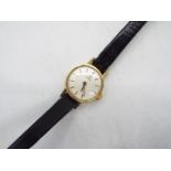 A lady's 9ct gold cased Omega wrist watch on black leather strap.