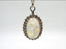 18ct gold - A white metal, opal and diamond pendant on a 56 cm white metal chain,