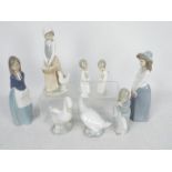 A collection of Lladro and Nao figures, largest approximately 24 cm (h).