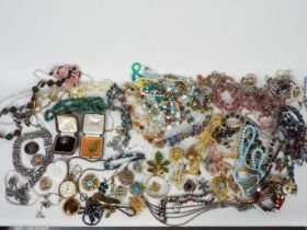A collection of various costume jewellery including a silver locket, necklaces, brooches,