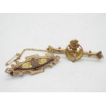 A 9ct gold bar brooch with floral decoration and safety chain and a further yellow metal brooch,