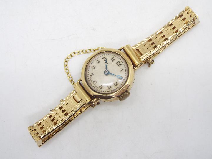 A lady's 9ct gold cased wrist watch on unmarked yellow metal bracelet with safety chain, 17.