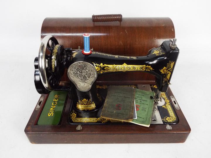 A vintage Singer sewing machine in wooden carry case.