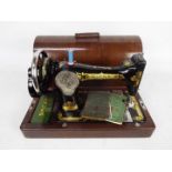 A vintage Singer sewing machine in wooden carry case.