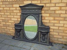 A cast iron over mantel mirror, approximately 100 cm x 118 cm.