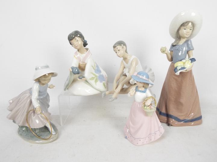 A collection of Nao and similar figures, largest approximately 31 cm (h).