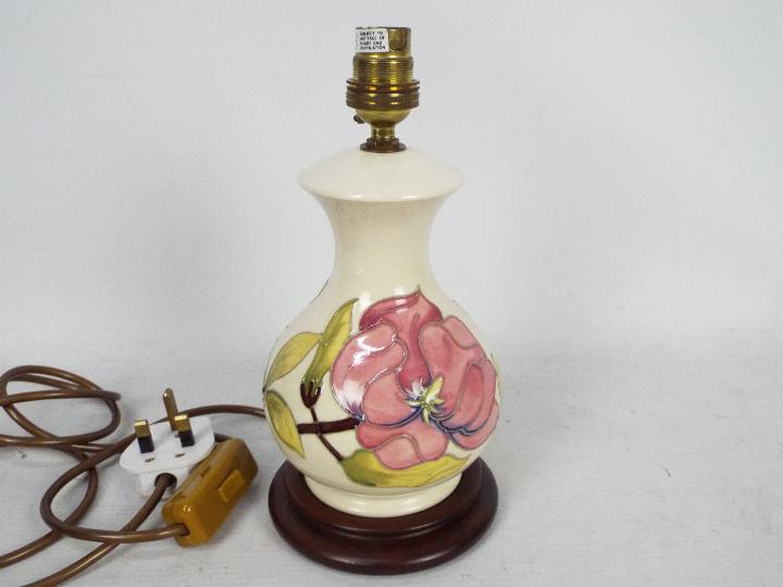 Moorcroft Pottery- a table lamp tubelined and hand painted with pink magnolia on a cream ground,