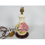 Moorcroft Pottery- a table lamp tubelined and hand painted with pink magnolia on a cream ground,