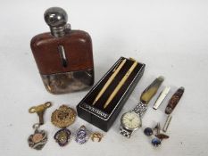 A mixed lot of collectables to include white metal hip flask, penknives, wrist watch,