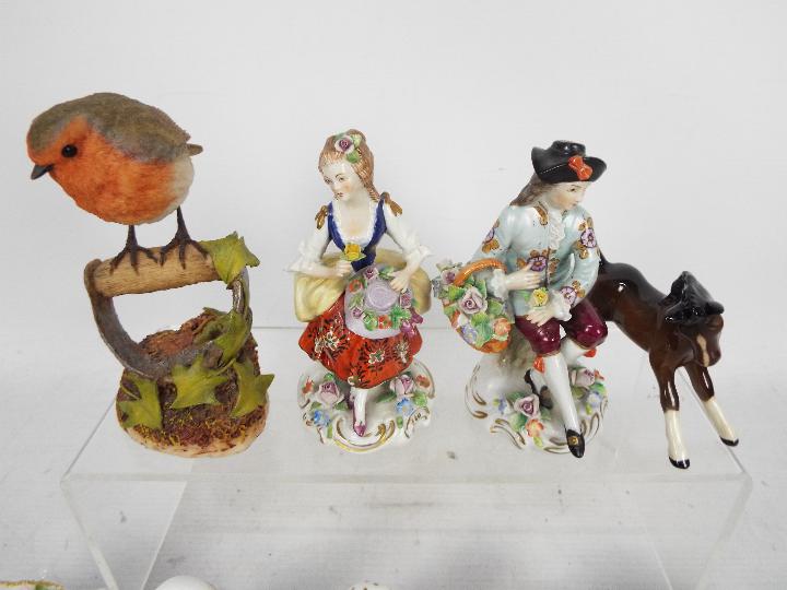 A pair of Sitzendorf figures comprising a seated gentleman with a basket of flowers and a lady - Image 2 of 4