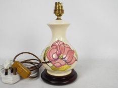 Moorcroft Pottery- a table lamp tubelined and hand painted with pink magnolia on a cream ground,