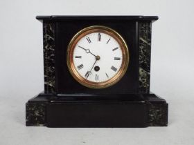 A black slate and marble mantel clock of architectural form, Roman numerals to a white dial,