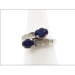 Platinum - A white metal, diamond and sapphire ring with sixteen channel set, baguette cut diamonds,