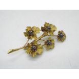 An 18ct gold stone set brooch in the form of a flowering branch,