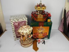 Christmas Decorations - Two boxed Christmas carousels comprising Santa's Carousel Park by Maisto