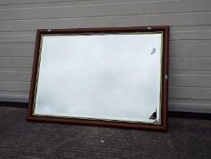 A wood framed wall mirror, approximately 70 cm x 100 cm.