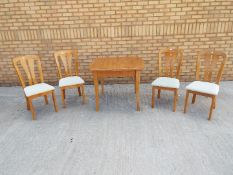An extending dining table and four chairs,