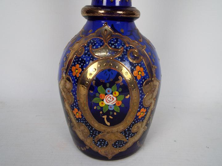 A blue glass decanter and stopper with hand painted floral and gilt decoration, - Image 2 of 3