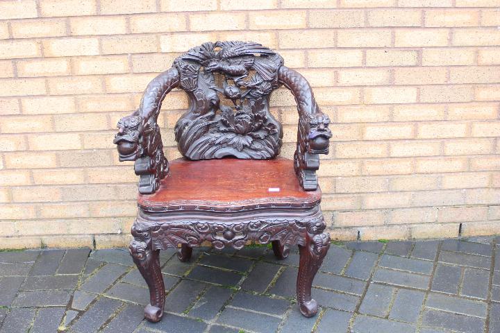 A profusely carved Chinese Dragon chair, carved dragon arms, phoenix to the backrest,