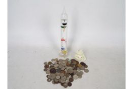 A small collection of coins and a Galileo thermometer, 28 cm (h).