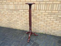 A mahogany torchere with twist column on