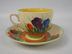 Clarice Cliff - a teacup and saucer hand painted in the Crocus pattern, Clarice Cliff,