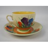 Clarice Cliff - a teacup and saucer hand painted in the Crocus pattern, Clarice Cliff,