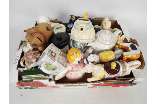A collection of teapots, novelty teapots and money banks.