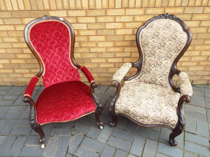 Two mahogany framed, upholstered armchairs with carved decoration.