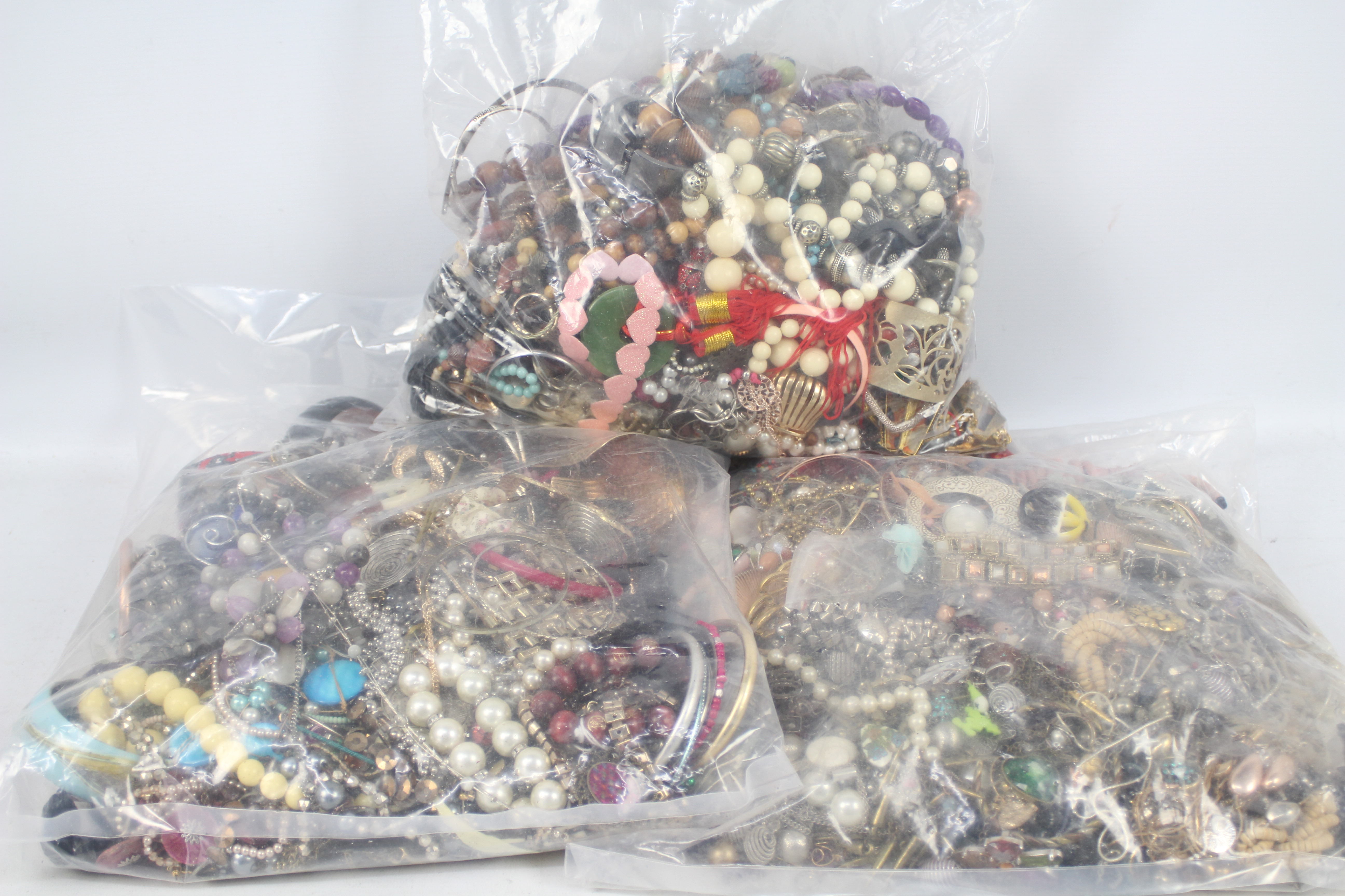 Costume Jewellery - Three clear, sealed bags of unsorted costume jewellery, approximately 13kg.