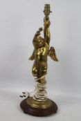 A gilt metal table lamp in the form of a putto, approximately 56 cm (h).