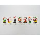 A cast iron, wall mountable, key or cup holder depicting The Seven Dwarfs,