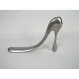 Manolo Blahnik - A polished aluminium novelty shoe horn in the form of a stiletto heel shoe,