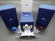 Swarovski Crystal - three large crystal tulips, red, blue, yellow in white metal display stand,