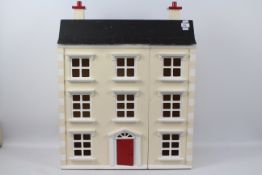 An unmarked opening front dolls house. The three storey unfurnished house measures approx.