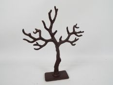 A cast iron jewellery hanger in the form of a tree trunk, 39 cm (h).