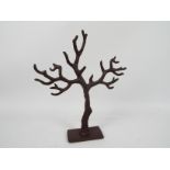 A cast iron jewellery hanger in the form of a tree trunk, 39 cm (h).