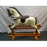 A vintage dapple grey rocking horse on trestle base, brown leather saddle, 112 cm (h),