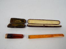 Two 9ct gold mounted cheroot holders contained in fitted cases, the larger case stamped pure amber,