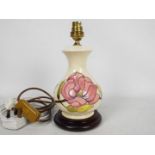 Moorcroft Pottery- a table lamp tubelined and hand painted with pink magnolia on a cream ground,