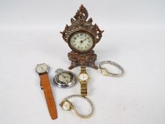 A collection of watches and a cast metal desk clock.