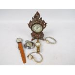 A collection of watches and a cast metal desk clock.