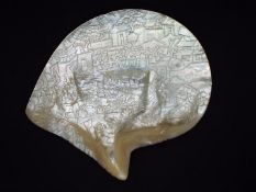 A Chinese mother of pearl shell carving depicting a battle scene with a background of buildings in