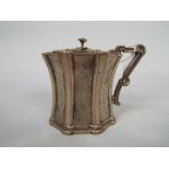 A Victorian silver mustard pot of waisted form, chased decoration and with flower finial,