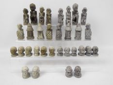 Ethnographica - An African carved stone chess set with 11 cm king.