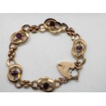 A stone set rose metal bracelet and heart padlock clasp,