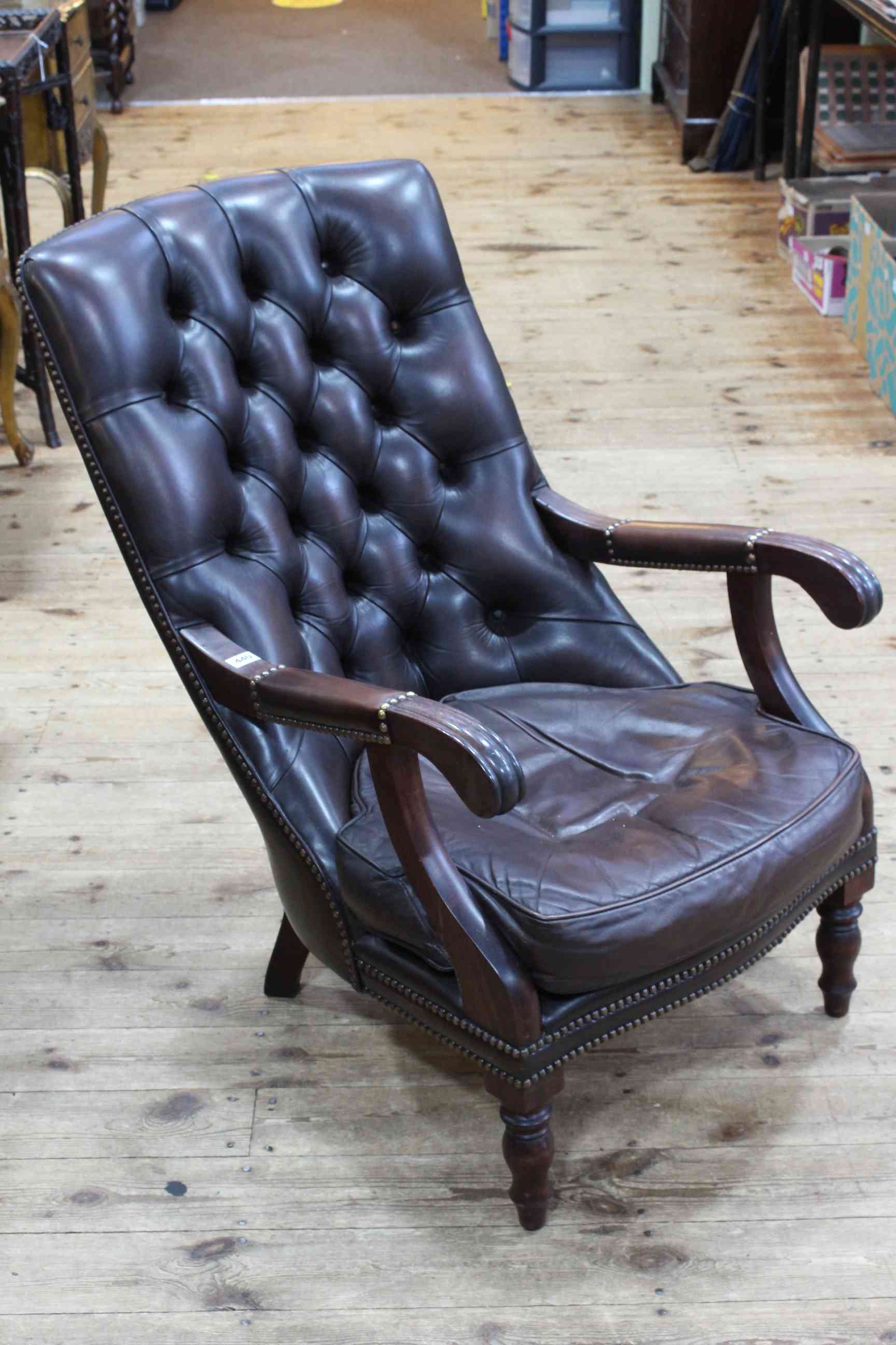 Brown leather button backed open armchair.