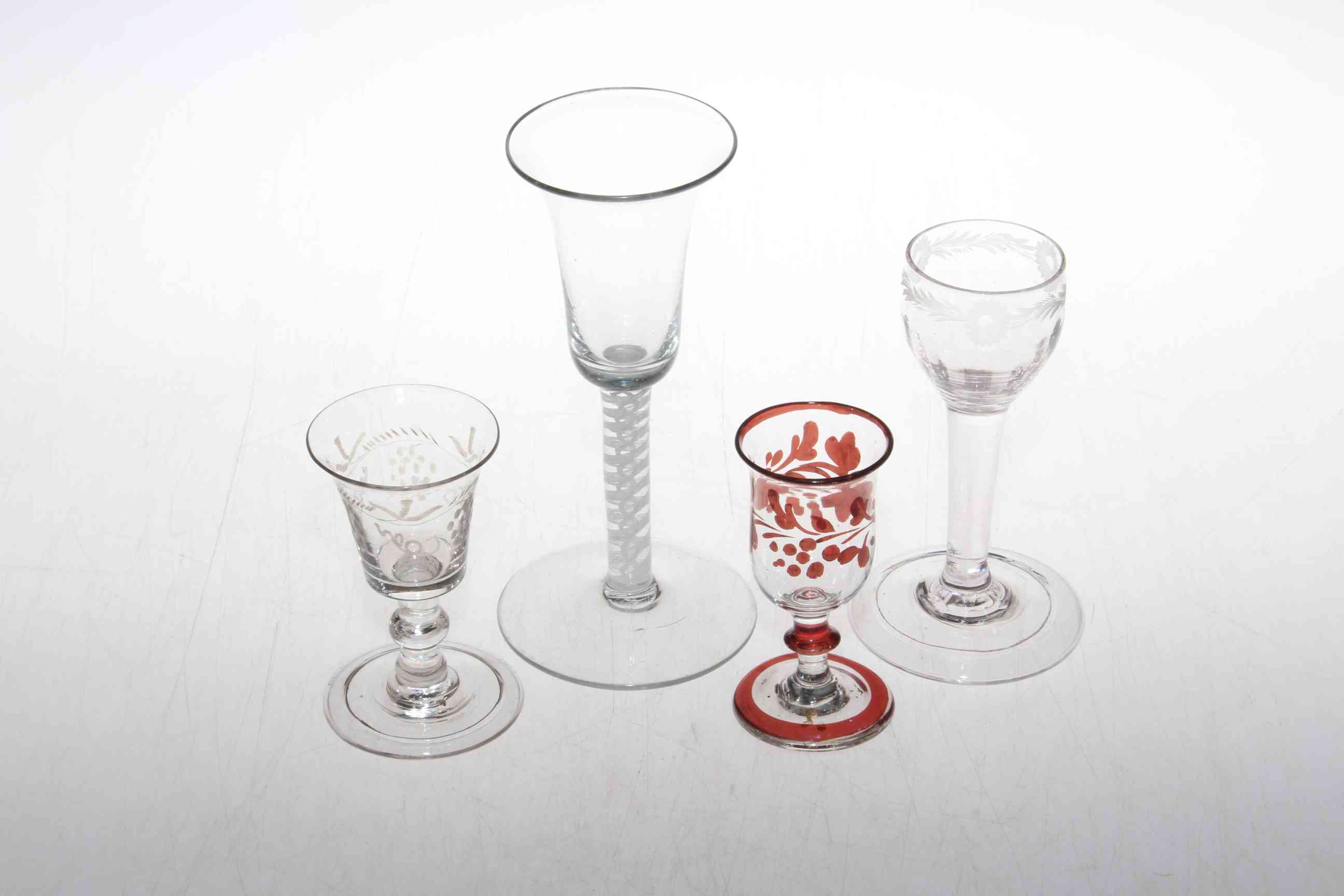 Four wine glasses including cotton twist stem glass, ruby overlaid glass and two etched glasses.