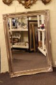 Silvered swept frame bevelled wall mirror, 104 x 75cm overall.