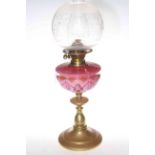 Victorian brass oil lamp with pink decorated glass reservoir and etched and frosted glass shade.